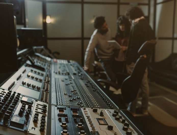 blurred group of musicians spending time at recording studio wit blurred group of musicians spending time at recording studio with graphic equalizer